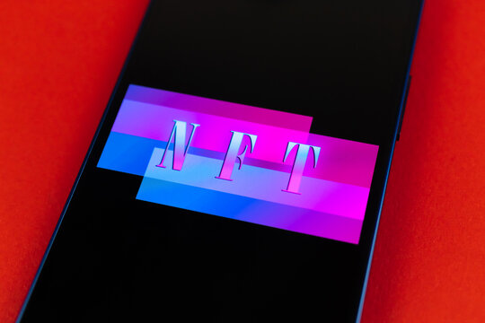 Smartphone with NFT application on abstract red background, top view photo