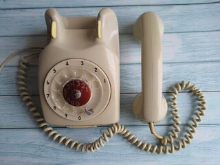 Retro style telephone, gray color, isolated on a wooden table.