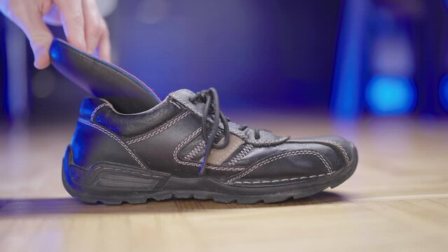 Person insert insole flat feet support into shoe close-up 4K