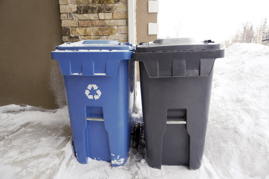 Blue and Black Garbage Trash Cans. Recycle and Regular Trash Collection.