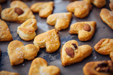Freshly puff dough heart shaped cookies, top view close up. St Valentine's Day concept. Abstract bakery background with copy space.
