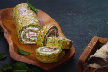 Spinach roulade filled with tomatoes, ham and ricotta for holiday dinner. Selective focus, copy...