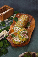 Tasty spinach roulade filled with ricotta cheese and ham. Freshly grated parmesan cheese. Selective focus, copy space