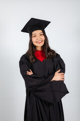 Smiling graduate student in mortarboard and bachelor gown on white background