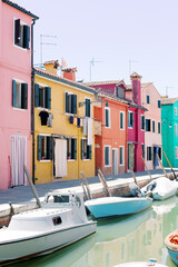 Fototapeta na wymiar Burano Island in Venice, Italy - Bright colored houses with boats in the water