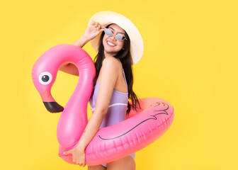 Beautiful Sexy asian woman in  bikini and smiling standing on yellow background isolated .Summer vocation happy trip concept.