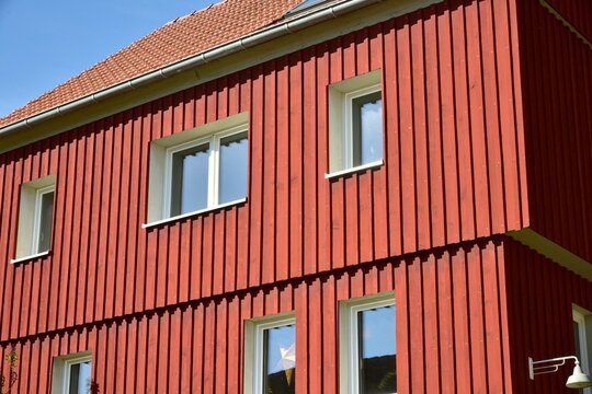 Fassade eines neu renovierten Wohnhauses, verschalt mit lasierten Holzplanken