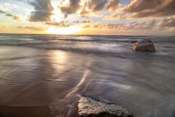 Naklejka premium Low angle wide view of the sunset at the sea Poleg beach Israel. Reflection of the sky