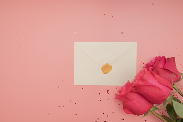 Card with space for text and red roses isolated on pink background.