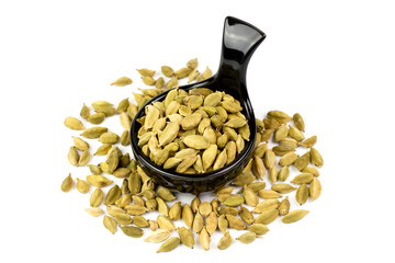 Green Cardamom on black ceramic bowl isolated on white background. Green cardamom is a fragrant herb used as an ingredient for cooking. 