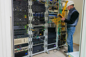 A technician works in a server room. Support for the network information infrastructure of the data...