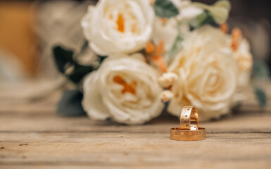 Fototapeta na wymiar Wedding rings and roses bouquet