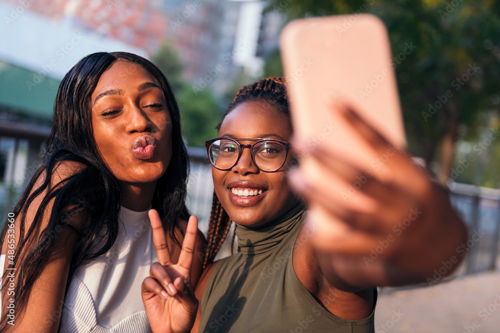 Wall mural two funny young black women taking a selfie