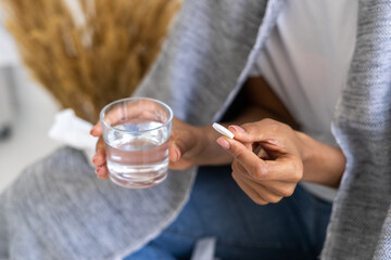 Woman hands with glass of water and pill
