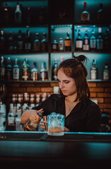 young  woman bartender Making Cocktail in bar
