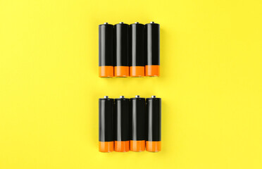 New AA batteries on yellow background, flat lay