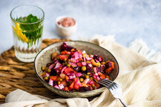 Bowl of mixed bean, beetroot, cucumber, carrot, cabbage salad and a glass of mint lemon water