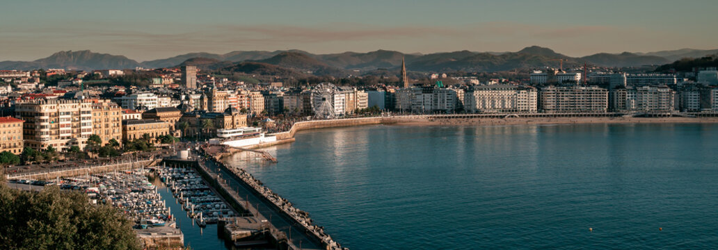 Panoramic view of La Concha Beach at sunset. The port, the town hall, the yacht club and the Ferris wheel.