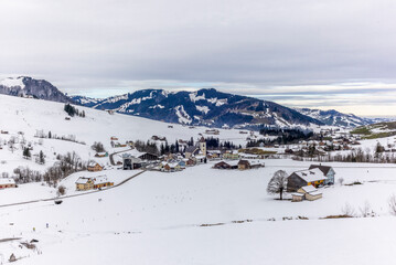 Fototapeta na wymiar Skiers starting a ski tour from the village of Bruelisau in the Swiss canton of Appenzell in winter