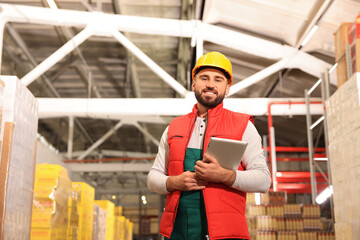 Naklejka na ściany i meble Man with tablet working at warehouse. Logistics center