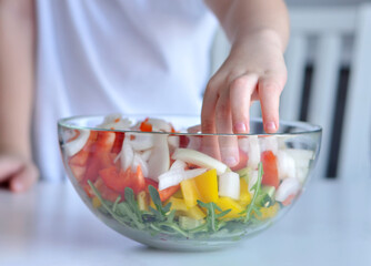 boy holding bowl with vegetables