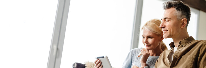Smiling middle aged white couple relaxing on a couch