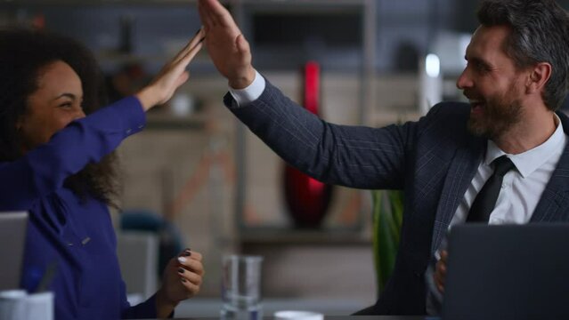 Business people clapping hands high five celebrate deal on multi ethnic meeting.