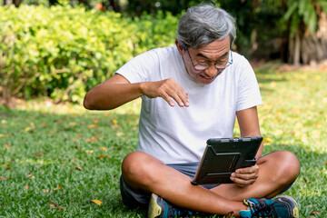 Fototapeta premium asian older man use a tablet.