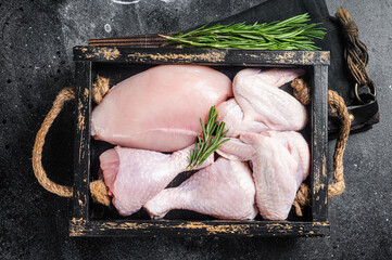 Fresh raw chicken meat and chicken parts - drumstick, breast fillet, wing, thigh. Black background....