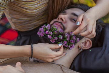 Obraz na płótnie Canvas man with flowers in his beard close-up