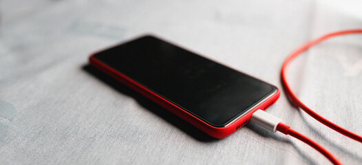 Mobile smartphone charging battery on office table close-up. Technology, multiple sharing and lifestyle concepts