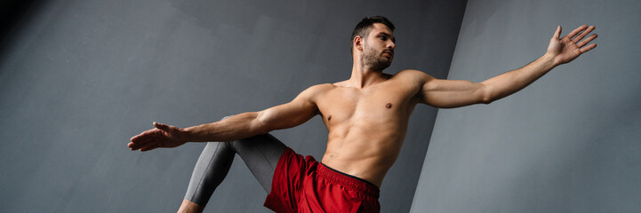 Obraz premium Young shirtless sportsman doing exercise with sport equipment indoors