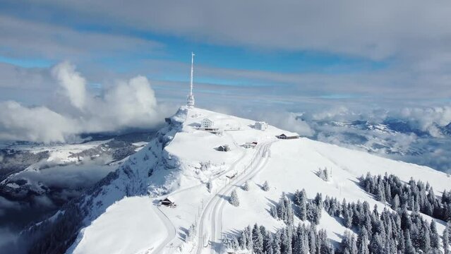 Aerial drone footage of the Rigi mountain summit with its train station above lake Lucerne in the alps in winter in Switzerland