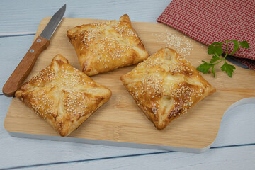 puff pastry with sesame seeds on a wooden board