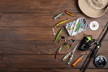 Fishing tackle - fishing spinning rod, hooks and lures on wooden background. Active hobby recreation concept. - 486549227