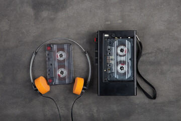Music listening concept. Vintage cassette tape, audio player and headphones close-up on grey...