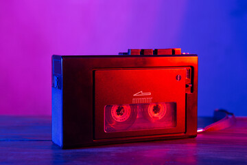 Vintage cassette tape player in neon light. 80s - 90s advertisement style. Disco party nostalgy concept - 486550015