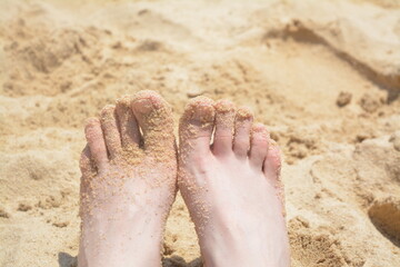 Feet on the sea beach in the sand