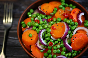 Healthy salad with carrots, green peas and blue onions. Vegan diet.