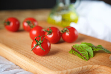 Red ripe cherry tomatoes lie on the surface of straw. The concept of food and healthy eating.
