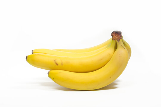 Bunches of yellow bananas lie on a white background, isolated