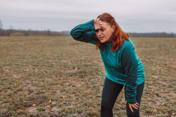Exhausted runner resting after after hard sport in autumn park. Healthy lifestyle concept. Active...
