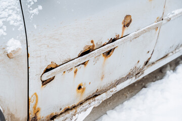 Traces of rust on a white car. Corrosion of the car body destruction of metal parts of the car body.