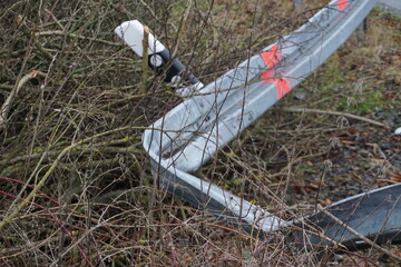 Kaputte, durch Unfall demolierte Leitplanke an Straßenrand bei Regen im Winter