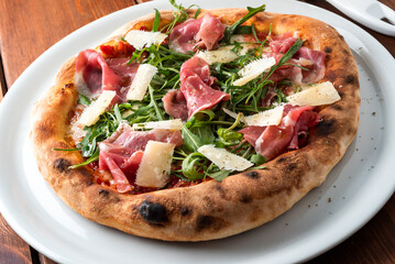 Deliziosa pizza con prosciutto di parma, rucola e scaglie di parmigiano, Cucina Italiana 