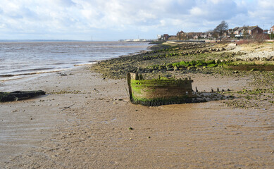 Remains of old wooden boats on a muddy shore