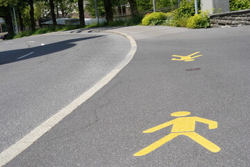Sidewalk with pictures of pedestrian in yellow color. Traffic marking of a sidewalk to emphasize that this part of street is for pedestrians.