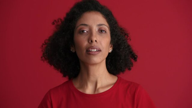 Smiling African woman positively shaking head in the red studio