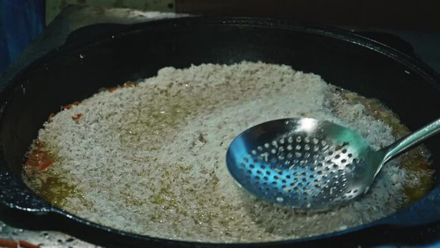 Slow motion of boiling rice in cauldron. Cooking for a big family.