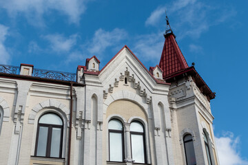 Fototapeta na wymiar Top floor of building with turrets against blue sky. Ukraine, Zhytomyr, February 11, 2022